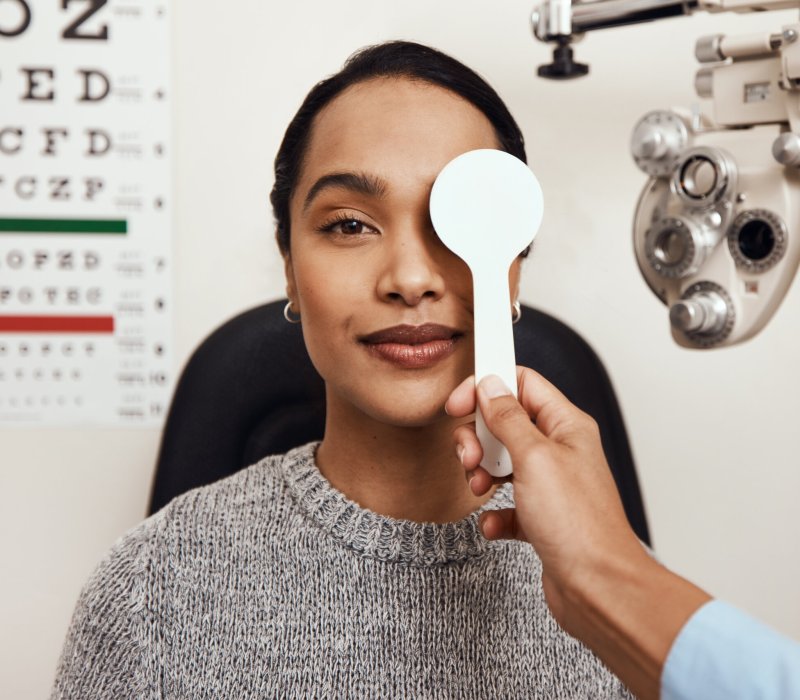 Shot of an optometrist covering her patients eyes with an occluder during an eye exam